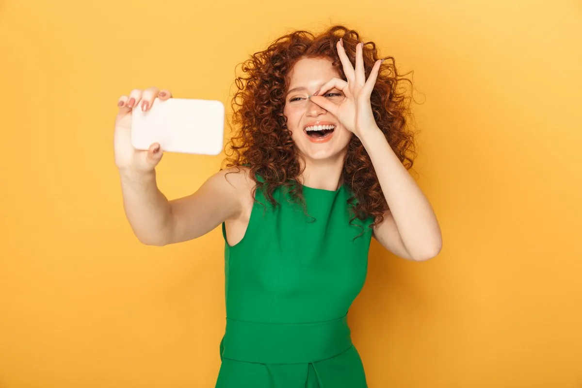 Criadora de conteúdo segurando o celular ao lado de produtos de beleza