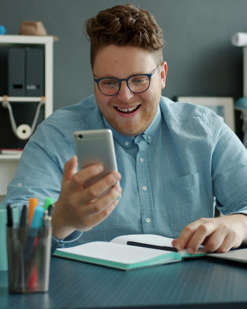 Lojista sorrindo ao ver uma nova venda no celular